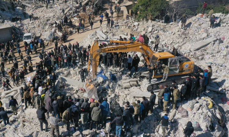 ista aérea mostra equipes de resgate em busca de sobreviventes em meio aos escombros de um prédio desabado na cidade de Harim, na província de Idlib, no noroeste da Síria, controlada por rebeldes, na fronteira com a Turquia