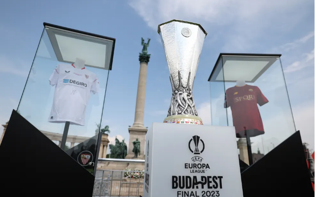 Camisas de Sevilla e de Roma expostas com o troféu da Liga Europa na Praça dos Heróis, em Budapeste - EFE/EPA/Anna Szilagyi