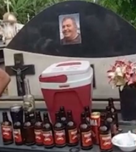 Filho de ex-prefeito faz homenagem com cerveja em cima do túmulo do pai em cemitério